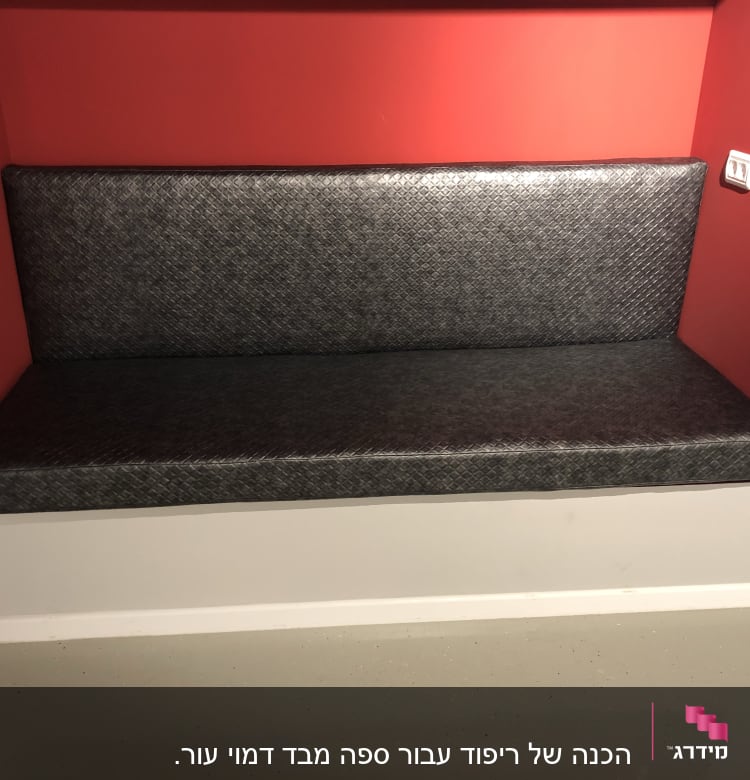 ריפוד ספסל אפור בתוך נישה אדומה בקיר